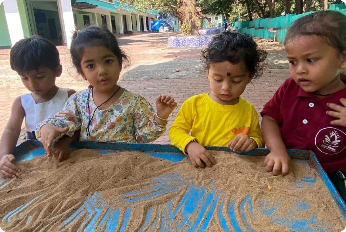 Children learning together at a sand table