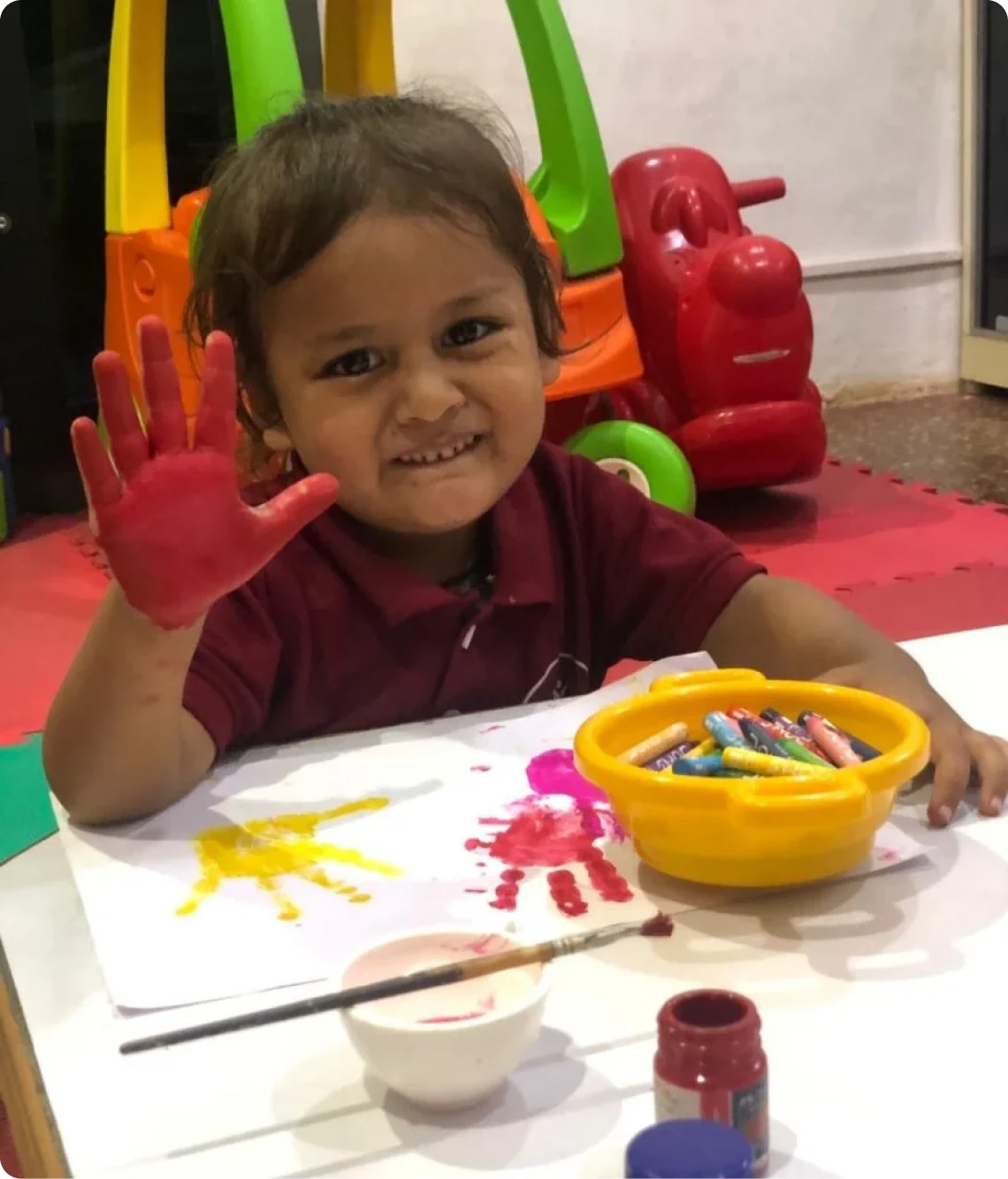 A child with painted hands at Shanti Niketan